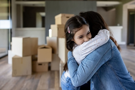 Woman hugging her daughter during a move after a custody agreement